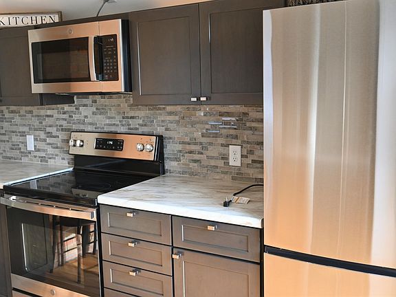 Kitchen featuring new stainless steel appliances.