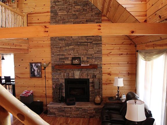 Towering wood-burning stone fireplace in the living area