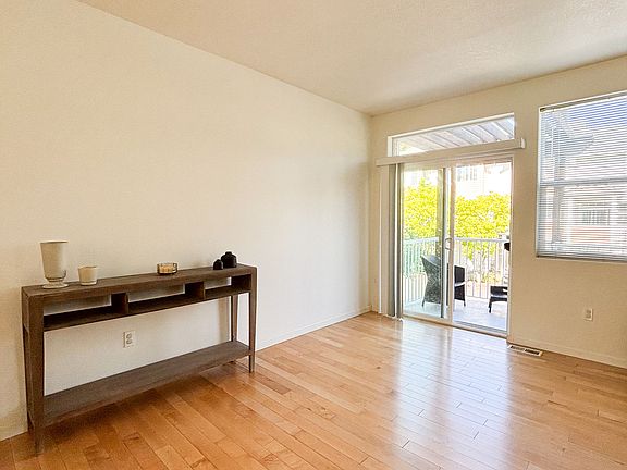 Living room looking out onto front balcony via sliding glass door.