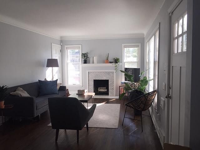 Sunny living room with fireplace and brand-new marble surround.