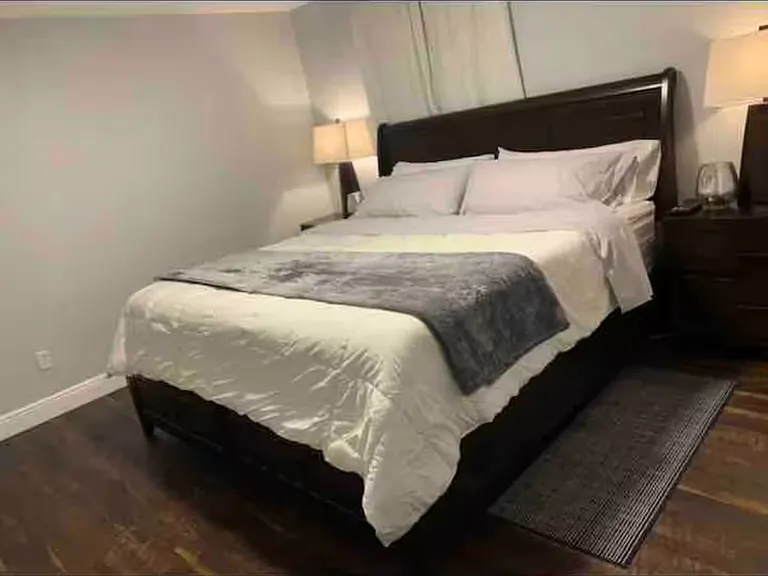 The master bedroom, which is now just been painted white has a very comfortable king size bed with two end tables and a large chest of drawers. There is also a 60 inch TV mounted on the wall in front of the bed which is not photographed.