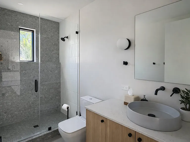 Beautifully designed guest bathroom with a walk-in shower, modern finishes, and natural light.
