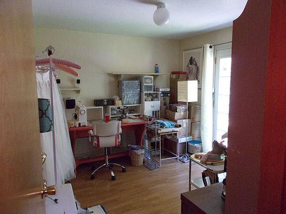 Second bedroom, facing the back yard. French door is at right. Tenant used this space for sewing, projects room.