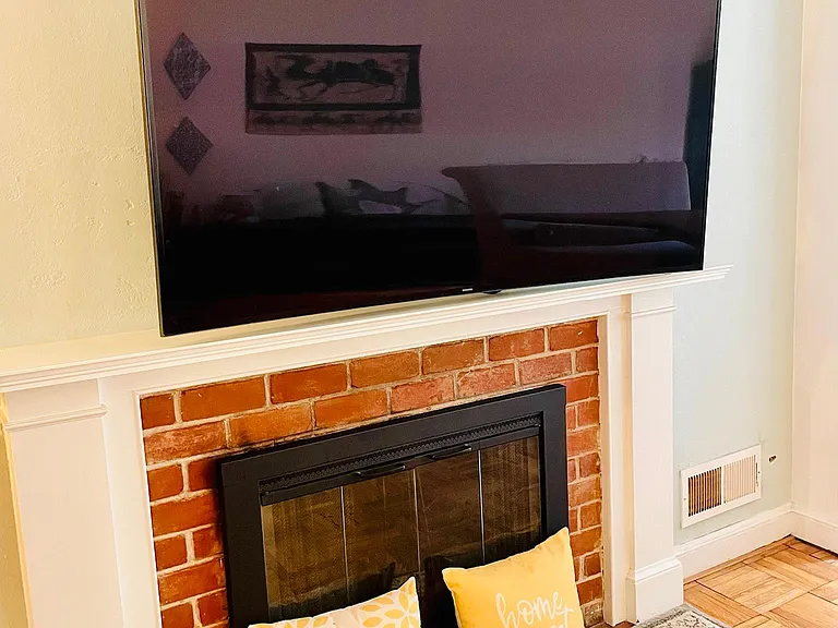 65'' Curved Screen Smart TV on top of the Fireplace.