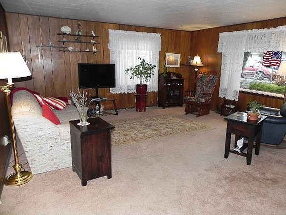 The spacious living room has hardwoods under the carpets and is open to the kitchen area.