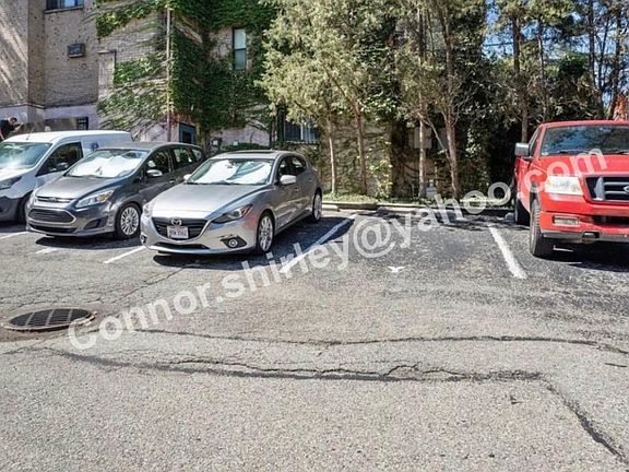Parking lot spot X where grey Mazda 3 is parked.