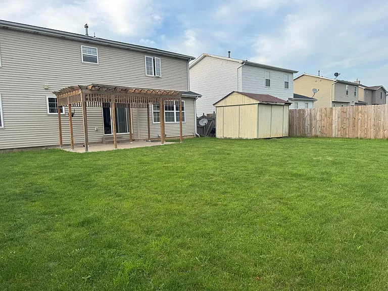 back of the house with storage shed