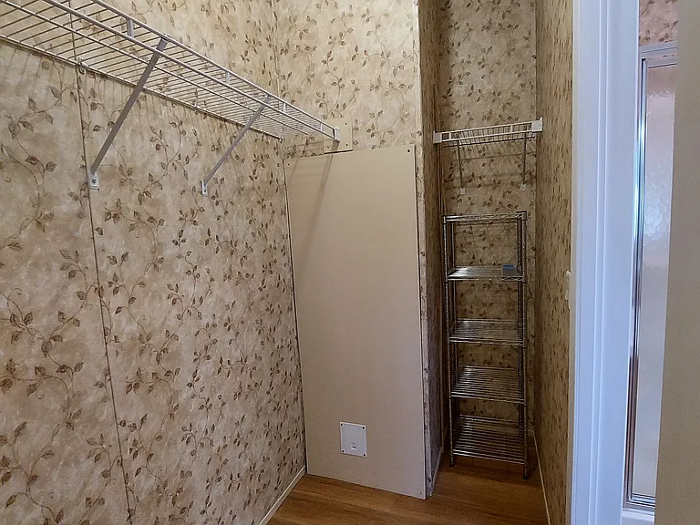 Closet has 10' of hanging clothes bar and shelving, plus a wire rack shelving unit.