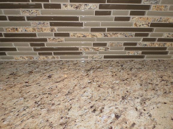 Granite kitchen counters with coordinating stone & glass back splash