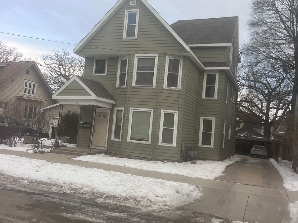 front of building showing driveway that is double wide in backyard