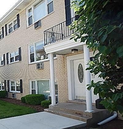 Entranceway with trees, flowers, view of forest preserve