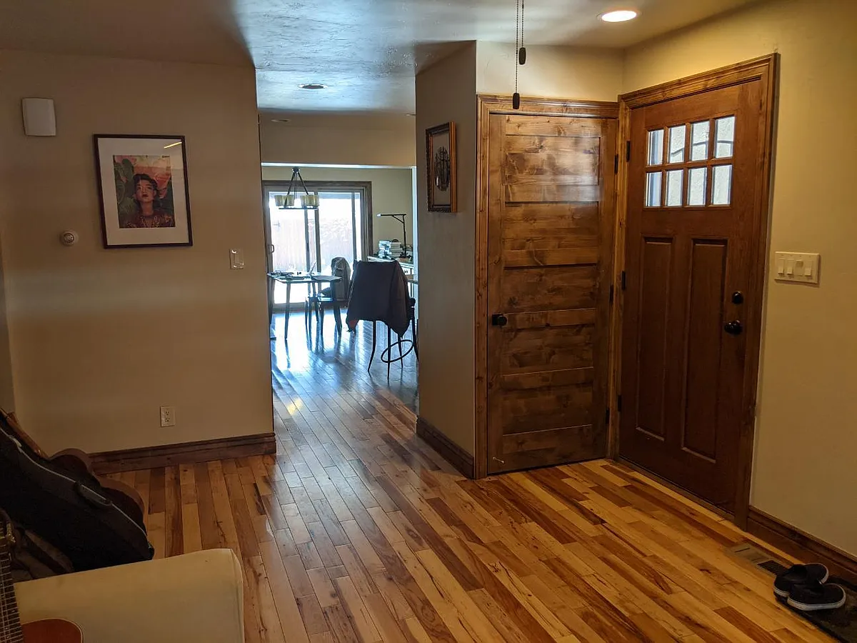 Front entrance with large coat/shoe closet and living room looking back towards dining room. 3/4" solid hickory wood flooring and kotty alder doors and trim throughout house. - 1608 S Lafayette St