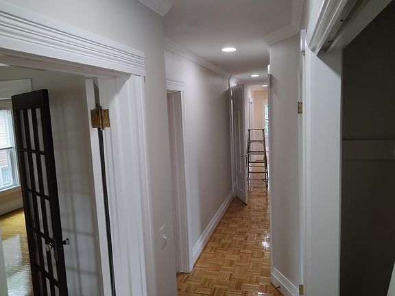 hallway from front stairs to back stairs of the house. access to hall closet, bedroom door, attic door and bathroom door and back spare bedroom/den door
