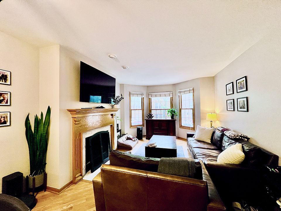 Wide open layout of main living room area with 3 bay windows, working fireplace