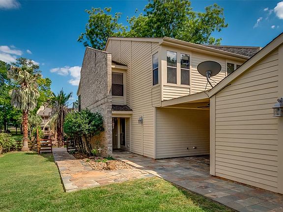 Here is a view just inside the fence looking at the front door. Notice the stone walkway and landscaping. It also has a covered walkway from the garage and covered front patio.