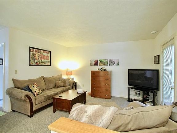 Living room features recessed lighting and a glass door leading to rear deck.