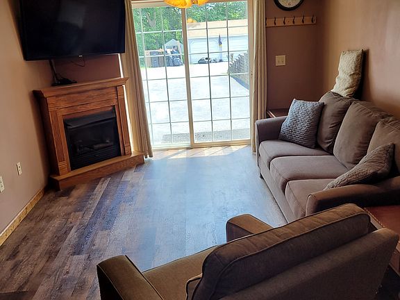 Living room with natural gas fireplace, Sofa, rocker recliner & 55" flat screen TV.