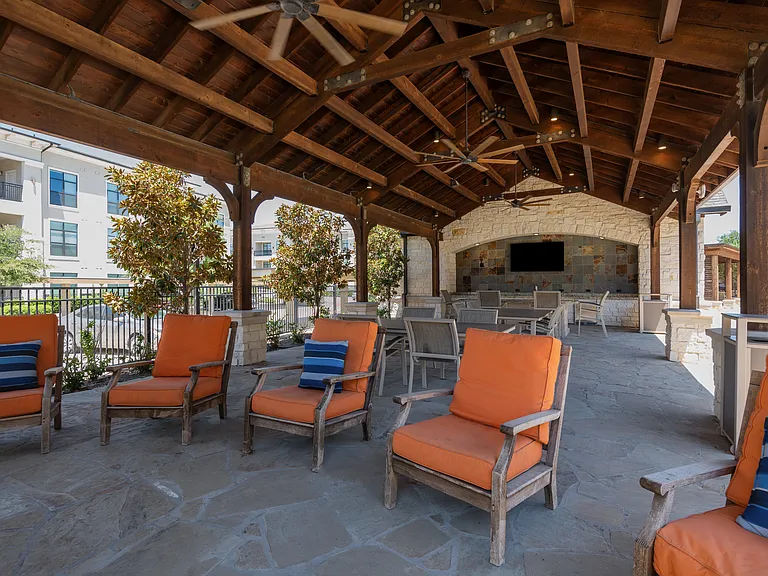 Unwind under the stars at The Hendry's outdoor lounge. Featuring a cozy fireplace and plush seating, this area offers a warm and inviting escape.