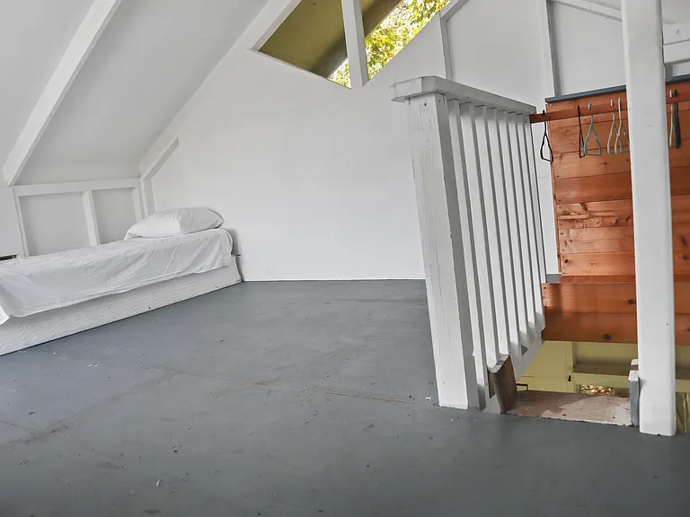 Upstairs loft with twin bed and natural lighting. This space could be used as an office, a guest room, or a meditation space.