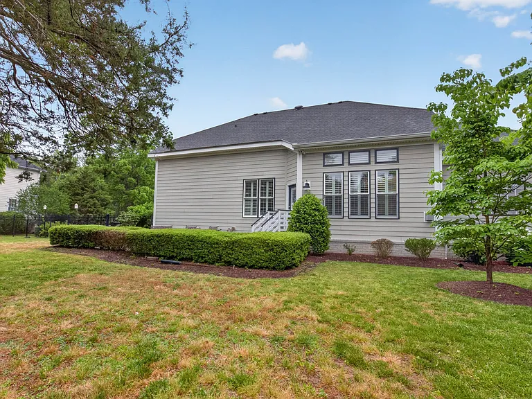 Manicured landscaping, fenced in backyard and large concrete patio
