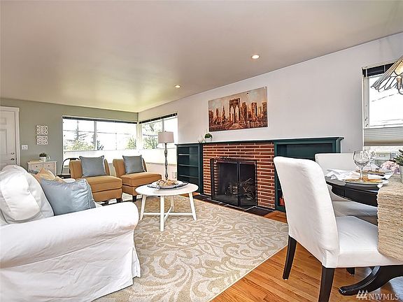 Main House Living Room w/ wood burning fireplace, hardwood floors, and lovely sound & mountain views.