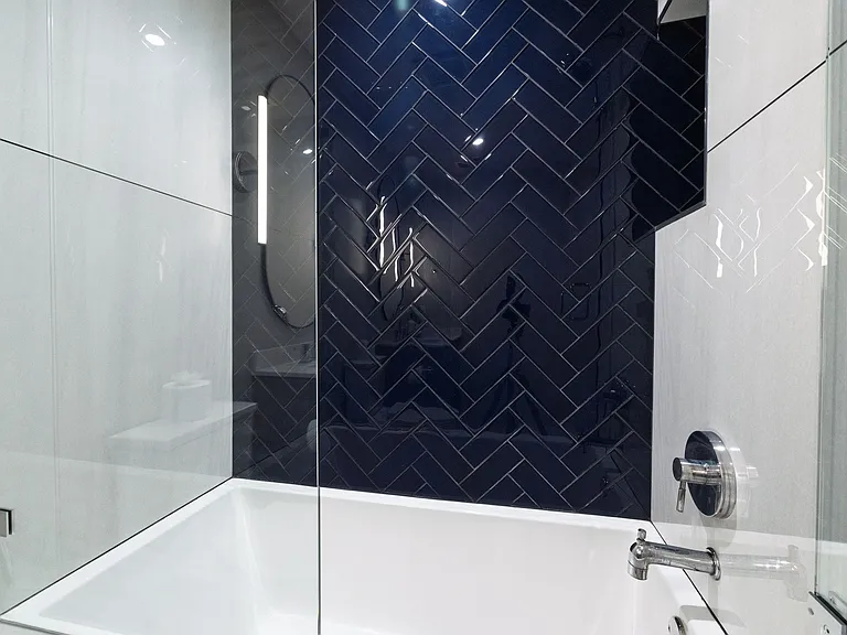 Bathroom 1 has a tub/shower combo with glass doors. There is a cabinet sink with oval mirror.