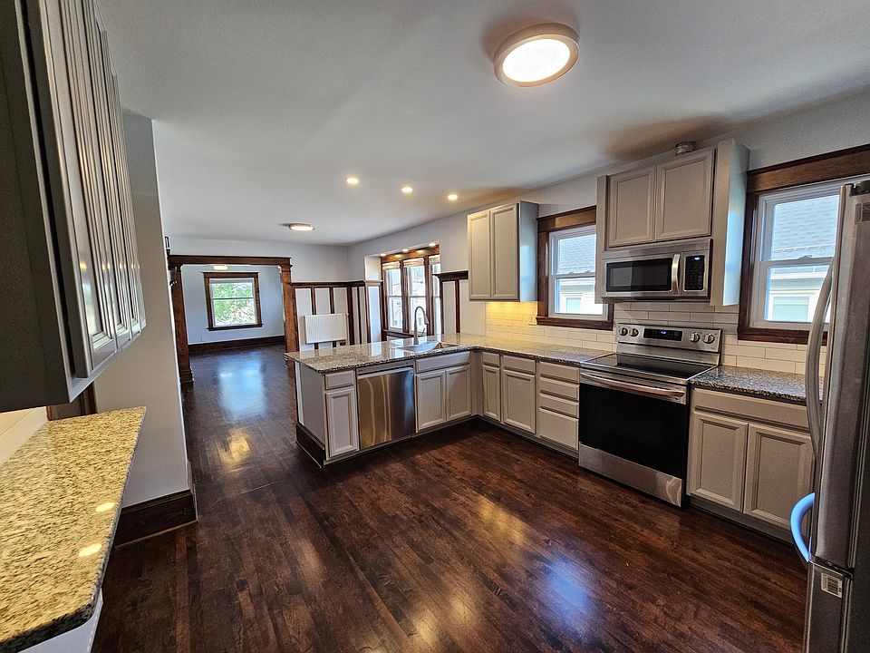 Large, open concept, kitchen with granite countertops. Kitchen includes new appliances: Glass top electric range, over range microwave with ventilation, refrigerator with water and ice dispensers, dishwasher, and garbage disposal.