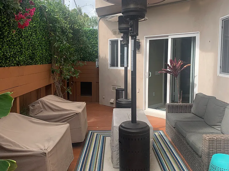 Outside Fenced Tropical Private Patio with Wicker Furniture, Heaters, Fire Pit, & Hot Tub