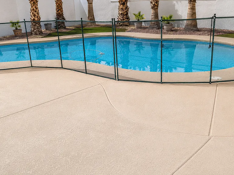 Clean fenced pool area with palm-tree backdrop