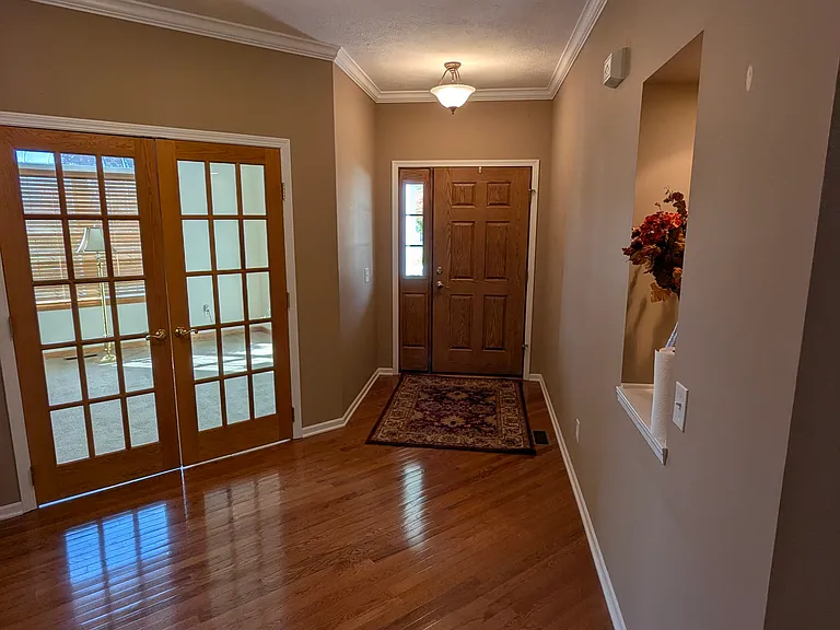 Foyer with hardwood floors, lighted wall niche, and entry to the office.