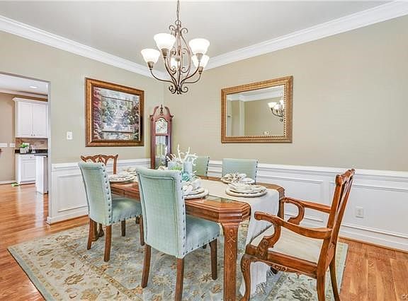 Dining room with hardwood floors, crown molding, picture frame molding and chair rail