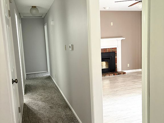 Upstairs hallway, showing cozy fireplace that opens to kitchen space