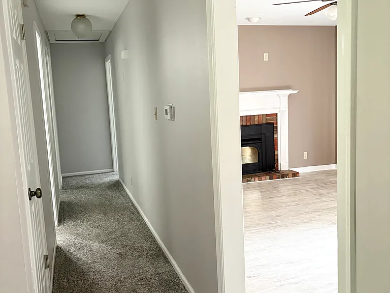 Upstairs hallway, showing cozy fireplace that opens to kitchen space