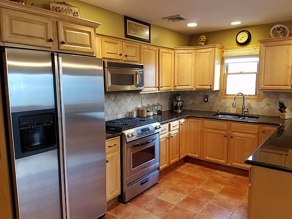 Kitchen area- includes refrigerator, dishwasher, stove, and microwave- Granite countertops, stainless steal sink