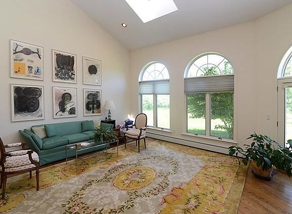 Formal sunken living room with hardwood floors and skylight.
