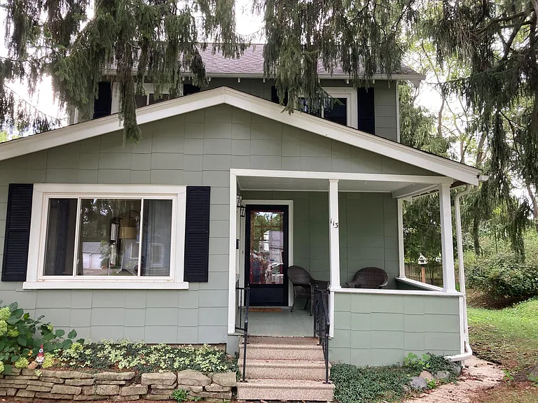 This is a view of the front of the house and the front porch and chairs.