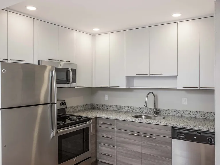 Modern kitchen features stainless steel appliances, granite countertops and designer cabinets