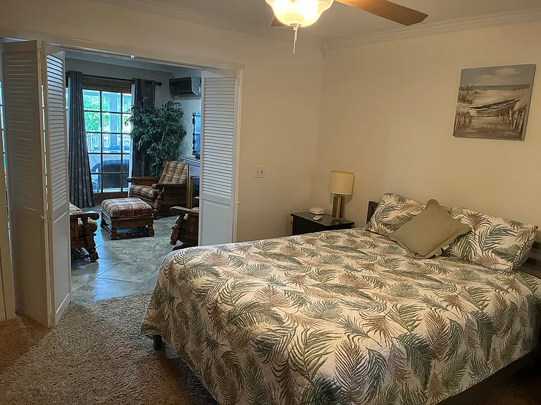 Large bedroom with queen size bed and dresser.