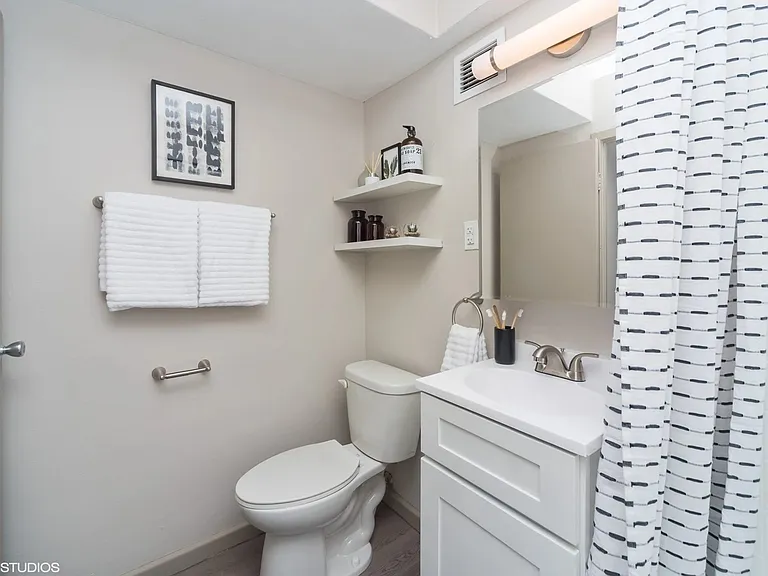 Upgraded bathroom with bright lighting at Archer Tower in Denver, CO