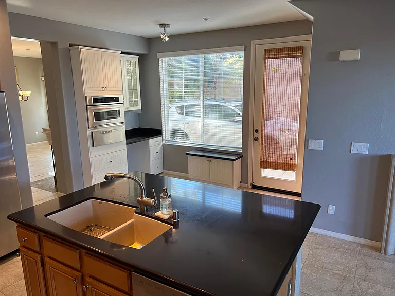 small office area, convection oven and microwave shown, side entry to driveway. there are 2 ovens and a warming drawer.