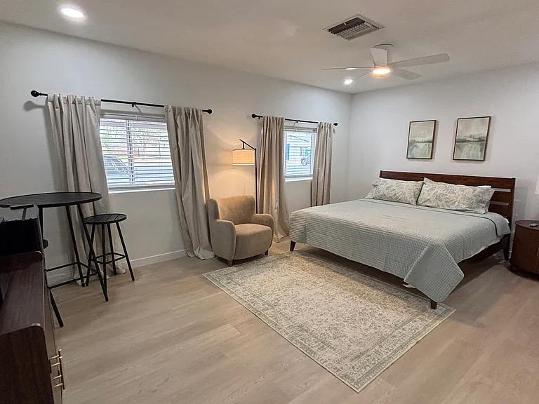 A private mini-kitchen setup in the corner _ Keurig, microwave, and mini-fridge _ plus an ensuite bath and closet, all within the room.