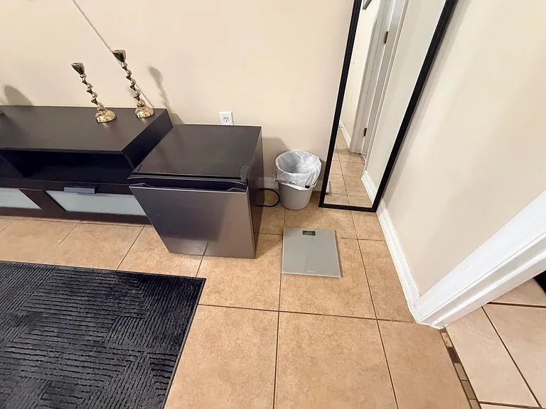 Tile-floored entry area offers space for storage and a full-length mirror for quick getting-ready checks.