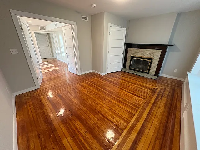 Primary bedroom with large front window. Fireplace does not work.