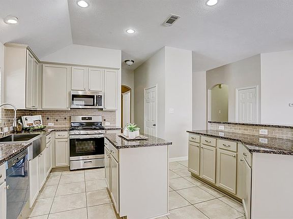 Another view of the kitchen with island and breakfast bar.