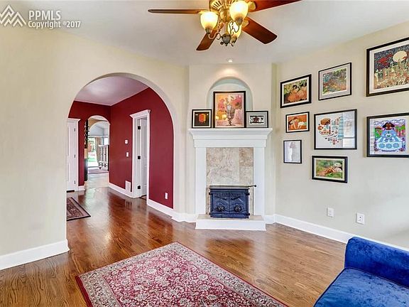 Dark stain hardwood floors.  Wood burning fireplace with travertine surround.
