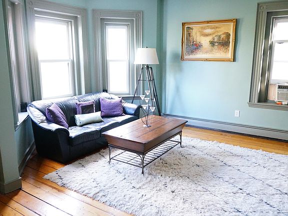 The roomy living space includes crown and floor moldings, custom window casings and two walls of exposure overlooking Monument Square.