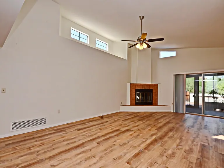 Light and bright living room with high ceilings, fireplace and view to back private patio!