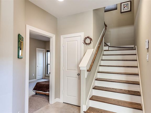 The facing view as you enter home. Easy to maintain tile covers Entry floor. Stairs are wood steps with white painted risers. Coat closet and storage to left of stairs. Open doorway leads into Secondary Bedroom and Bath. Master is on 2nd floor, so be