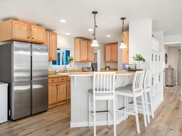 Open concept kitchen a bar with all stainless steel appliances and ample cabinet space