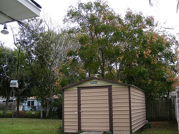 Backyard is partially fenced and includes storage shed.